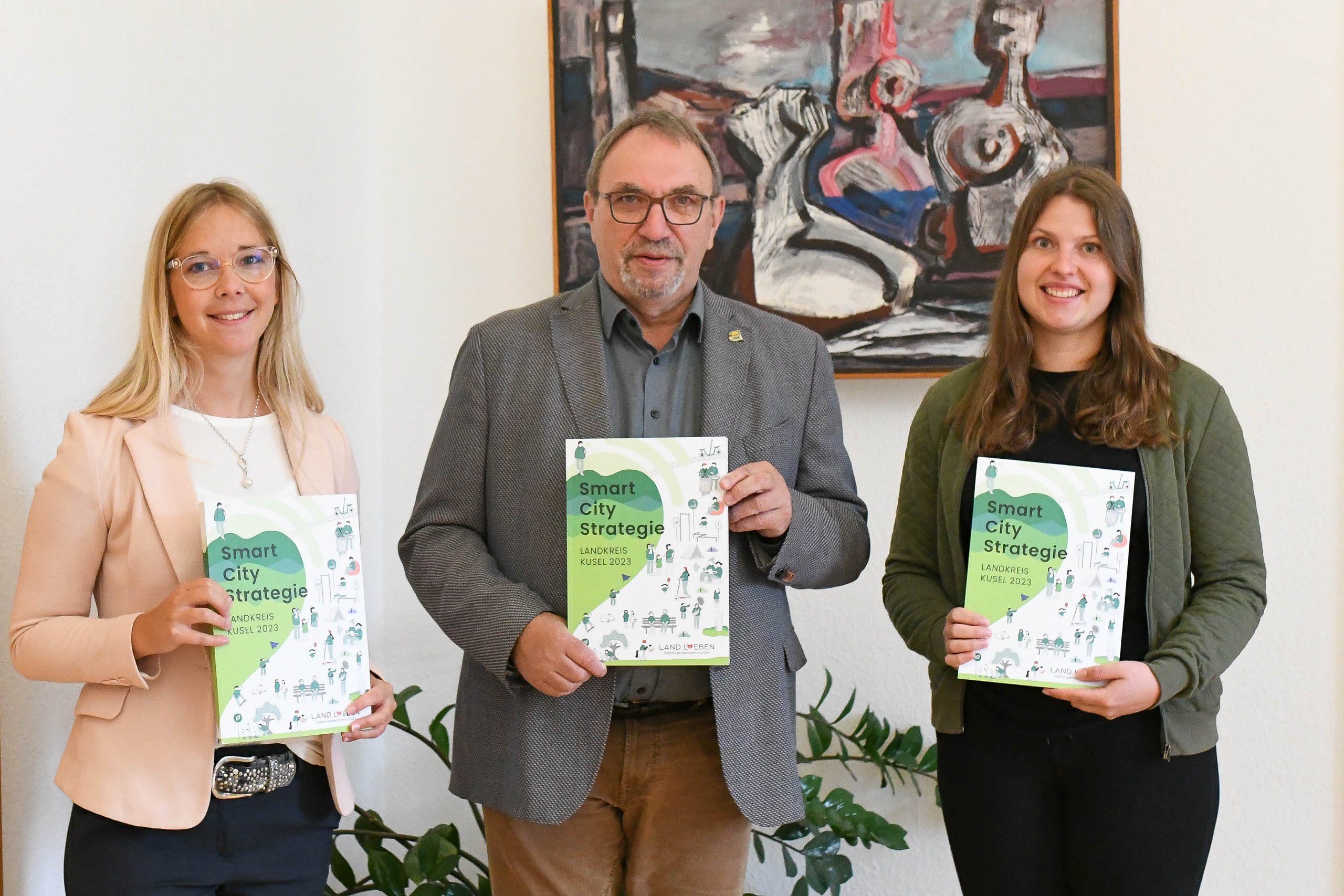 Landrat mit Team von Landlieben mit gedruckter Version des Strategiepapiers